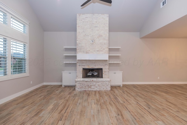 unfurnished living room featuring ceiling fan, a fireplace, light wood-style flooring, baseboards, and visible vents