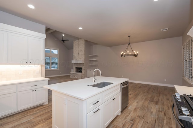 kitchen featuring open floor plan, a sink, light wood finished floors, and stainless steel appliances