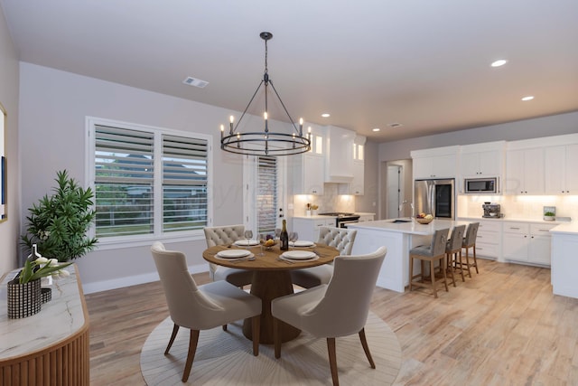 dining area with recessed lighting, an inviting chandelier, light wood-style flooring, and visible vents