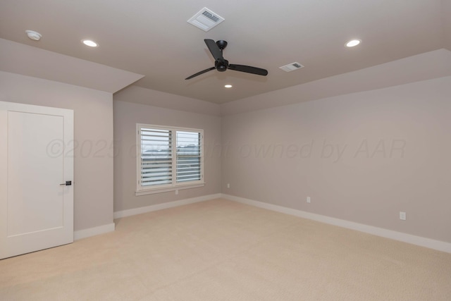 spare room with baseboards, ceiling fan, light carpet, and visible vents