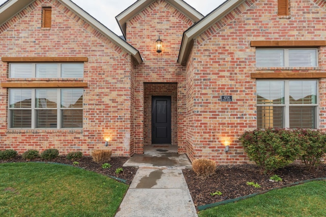 view of exterior entry with brick siding