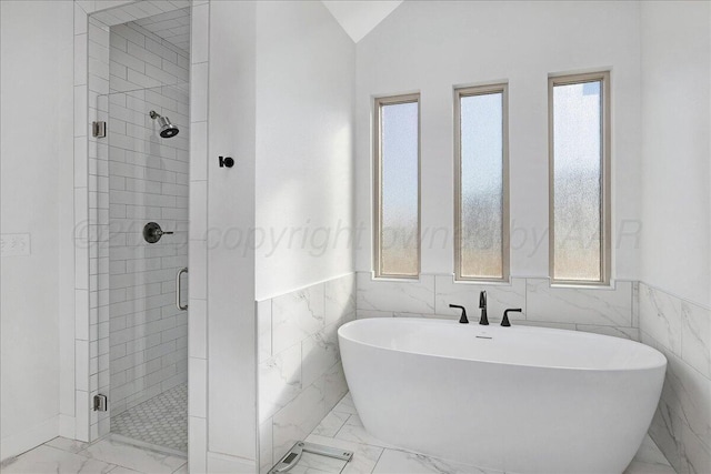 bathroom with vaulted ceiling, plenty of natural light, and separate shower and tub