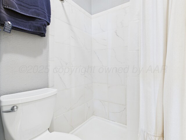 1409 Bailey Ave, Dumas, TX 79029 - bathroom featuring toilet and a tile shower