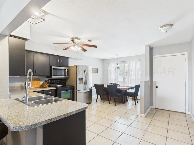 1409 Bailey Ave, Dumas, TX 79029 - kitchen with stainless steel appliances, light countertops, ceiling fan, light tile patterned floors, and hanging light fixtures