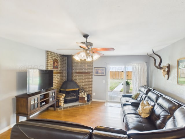 1409 Bailey Ave, Dumas, TX 79029 - living room with a wood stove, wood finished floors, and a ceiling fan
