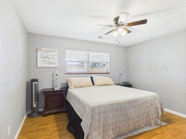 1409 Bailey Ave, Dumas, TX 79029 - bedroom with light wood-style floors and ceiling fan