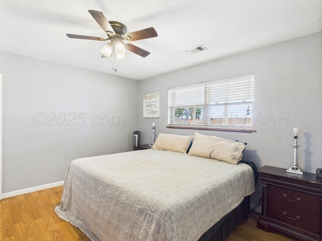 1409 Bailey Ave, Dumas, TX 79029 - bedroom featuring wood finished floors and ceiling fan