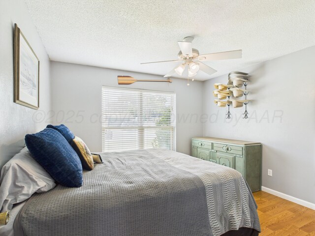 1409 Bailey Ave, Dumas, TX 79029 - bedroom with light wood finished floors, ceiling fan, and a textured ceiling