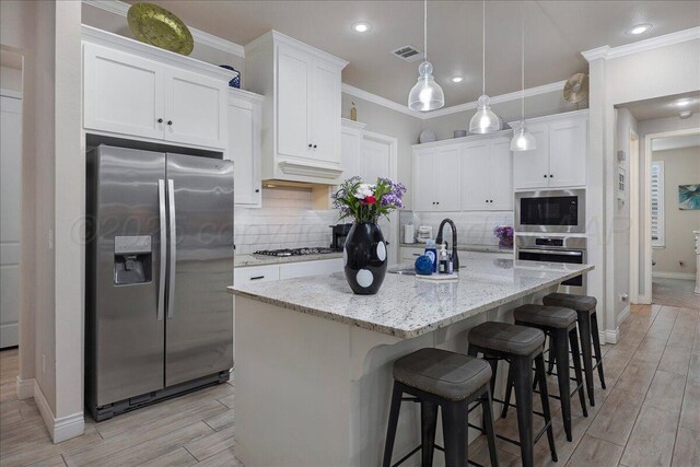 9109 Staten Island St, Amarillo, TX 79119 - kitchen with appliances with stainless steel finishes, tasteful backsplash, white cabinetry, light wood-style floors, and light stone counters