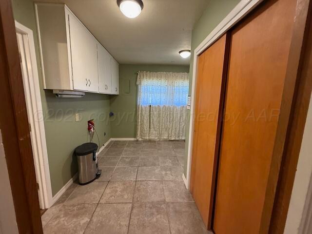 laundry room with baseboards, cabinet space, light tile patterned flooring, and washer hookup