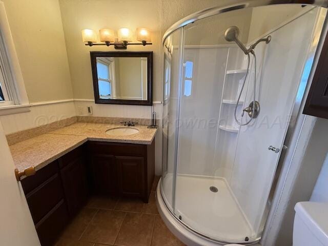 full bath with tile patterned floors, vanity, a shower stall, and toilet