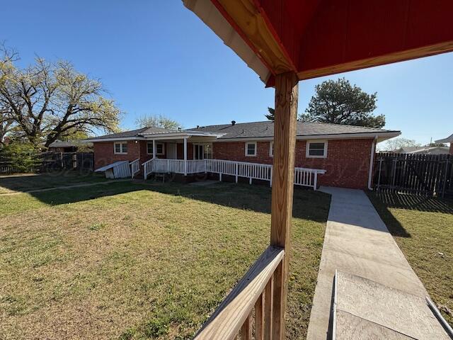 back of house with fence and a yard