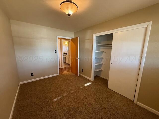unfurnished bedroom featuring carpet, a closet, and baseboards