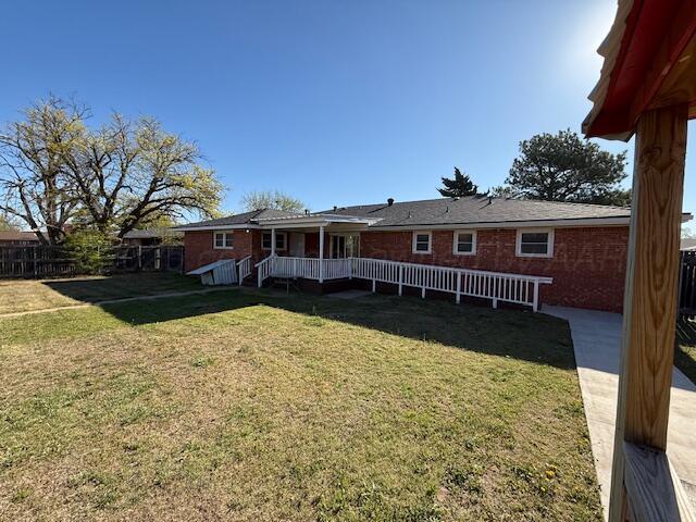 back of house with fence and a yard
