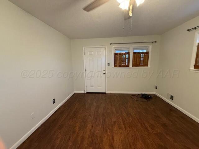 empty room featuring visible vents, wood finished floors, baseboards, and ceiling fan
