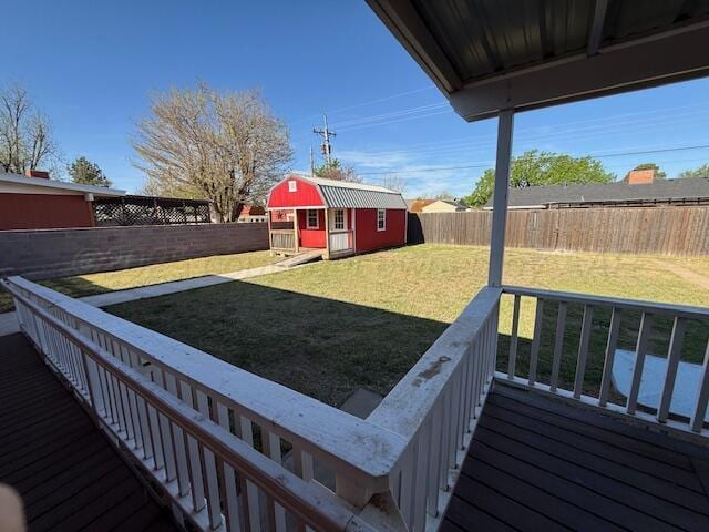 view of yard with a fenced backyard, an outbuilding, a storage shed, and a deck