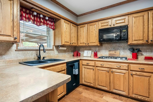 kitchen featuring crown molding, backsplash, a sink, light wood-style flooring, and black appliances