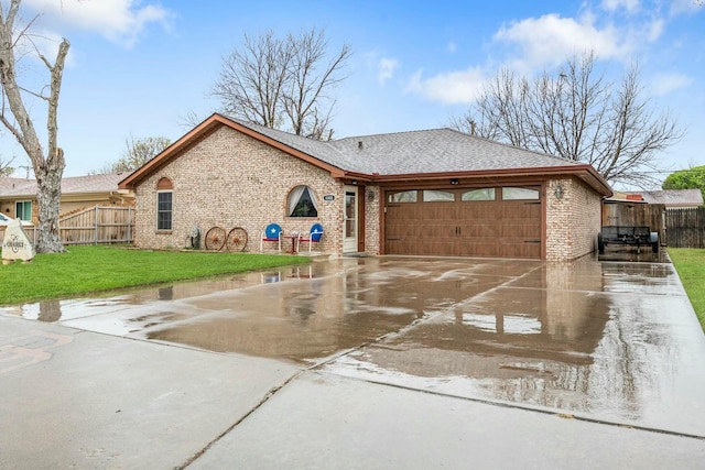 view of front facade with fence, a garage, concrete driveway, brick siding, and a front lawn