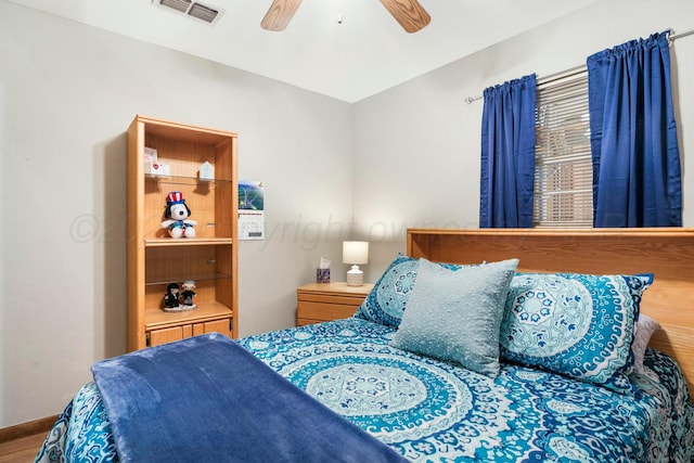 bedroom with wood finished floors, baseboards, ceiling fan, and visible vents