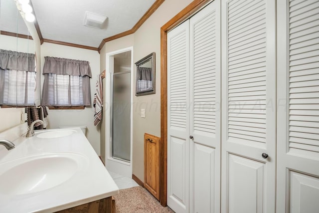full bath featuring a sink, crown molding, a closet, and a shower stall