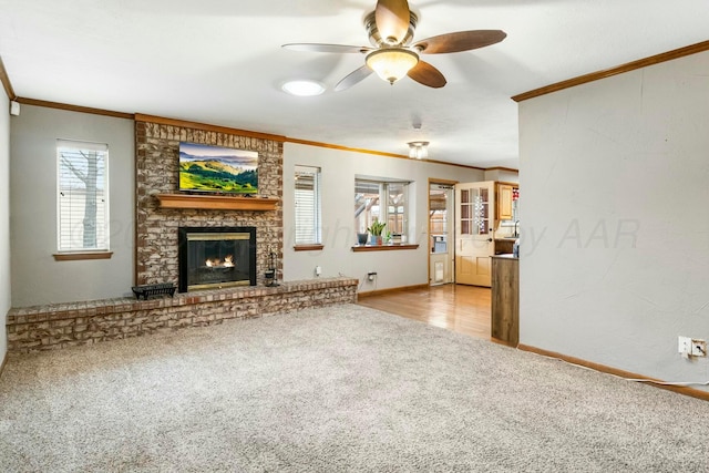 unfurnished living room featuring a brick fireplace, ornamental molding, carpet, and a ceiling fan