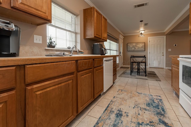 1107 Yucca Ave, Amarillo, TX 79108 - kitchen featuring white appliances, light tile patterned flooring, brown cabinets, crown molding, and a sink