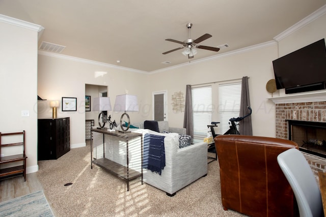 living room featuring ceiling fan, ornamental molding, a fireplace, and wood-type flooring