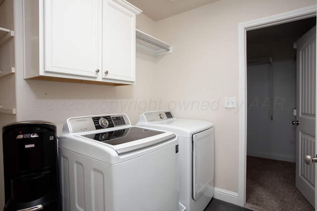 clothes washing area with washing machine and dryer and cabinets