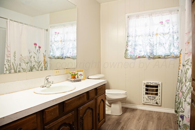 1215 S Main St, Hereford, TX 79045 - bathroom with heating unit, vanity, wood finished floors, toilet, and a shower with curtain