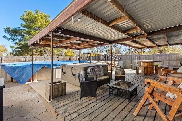 wooden terrace with a fenced backyard, a fenced in pool, and an outdoor living space with a fire pit