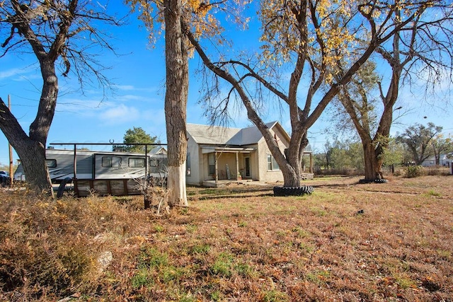 back of house with a yard and stucco siding