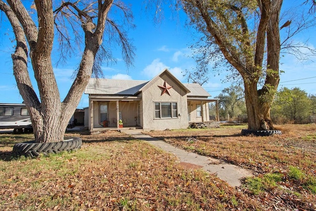 view of front of home featuring stucco siding, a porch, and a front yard