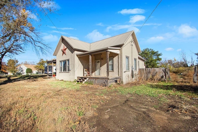 exterior space with a yard, metal roof, and stucco siding