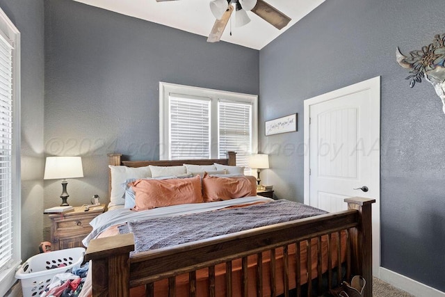 carpeted bedroom with ceiling fan and baseboards