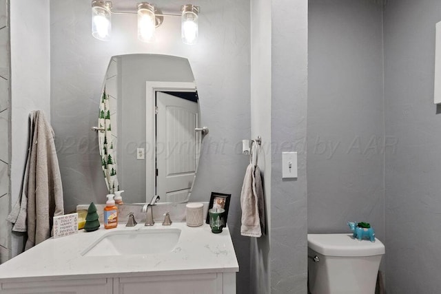 half bathroom with vanity and toilet