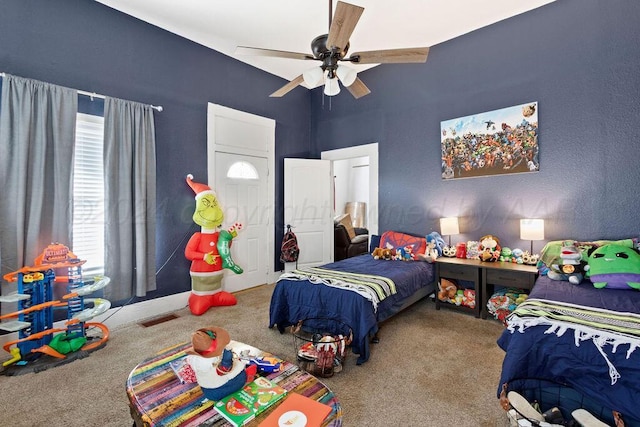 carpeted bedroom featuring a ceiling fan and visible vents