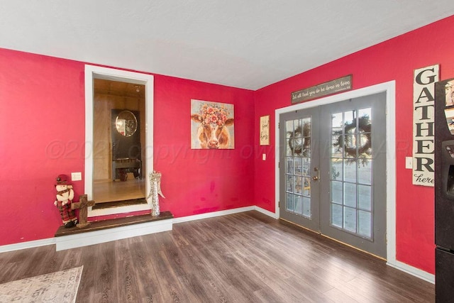 foyer entrance with baseboards, wood finished floors, and french doors