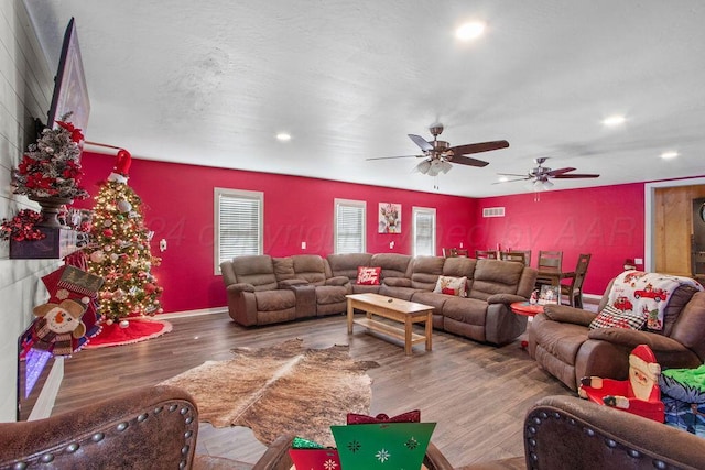 living room with recessed lighting, visible vents, and wood finished floors