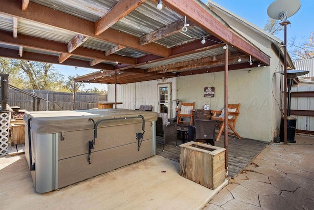 view of patio with fence and a hot tub