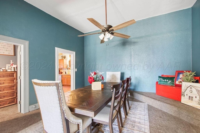 dining room featuring carpet, vaulted ceiling, and a ceiling fan