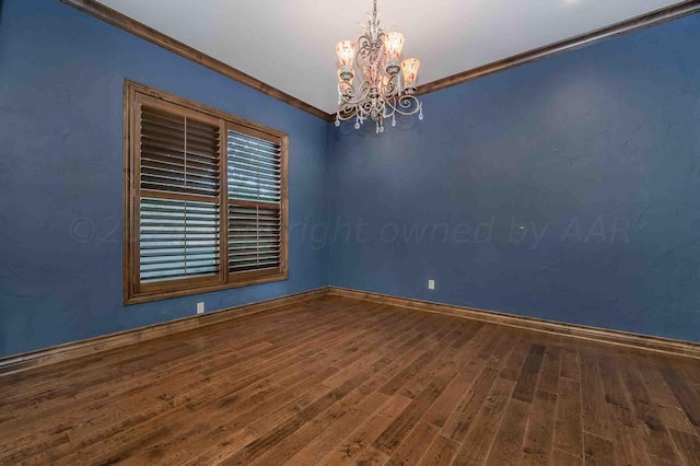 spare room with a chandelier, hardwood / wood-style floors, and ornamental molding