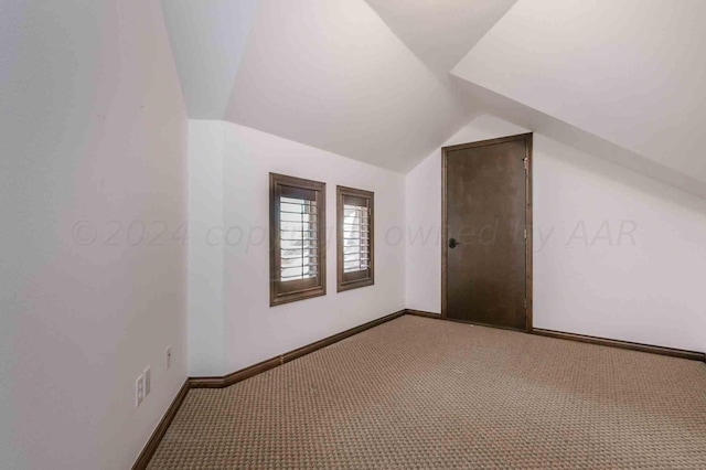 bonus room with lofted ceiling and carpet floors