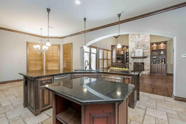 kitchen with decorative light fixtures, sink, and a center island