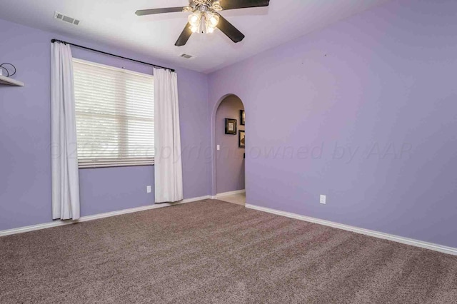 empty room featuring ceiling fan and carpet