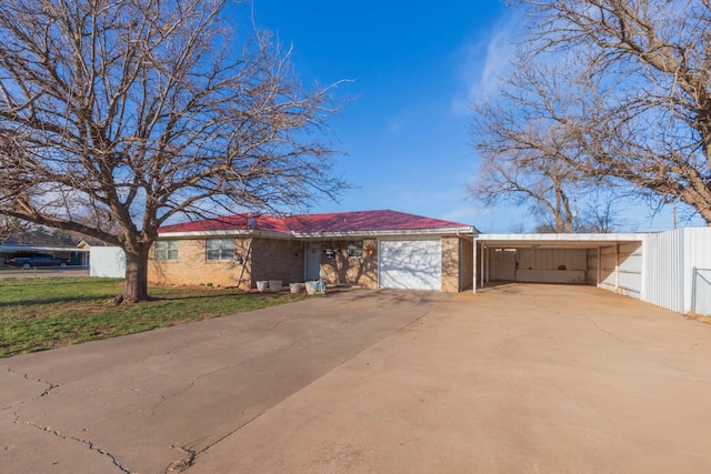 single story home with an attached carport, driveway, an attached garage, and a front yard