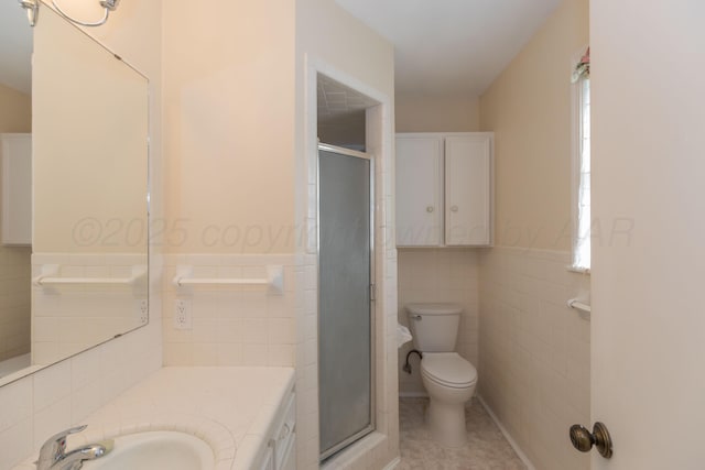 6710 Gainsborough Rd, Amarillo, TX 79106 - bathroom with tile walls, a stall shower, tile patterned flooring, vanity, and a wainscoted wall
