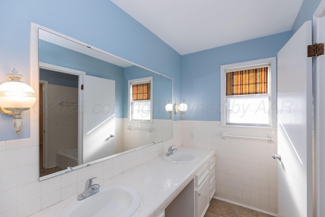 6710 Gainsborough Rd, Amarillo, TX 79106 - bathroom featuring tile walls, double vanity, a wainscoted wall, and tile patterned flooring