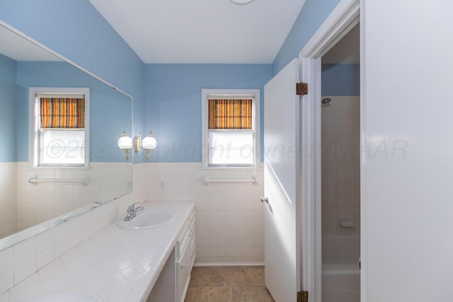 6710 Gainsborough Rd, Amarillo, TX 79106 - bathroom with tile walls, double vanity, and a wainscoted wall