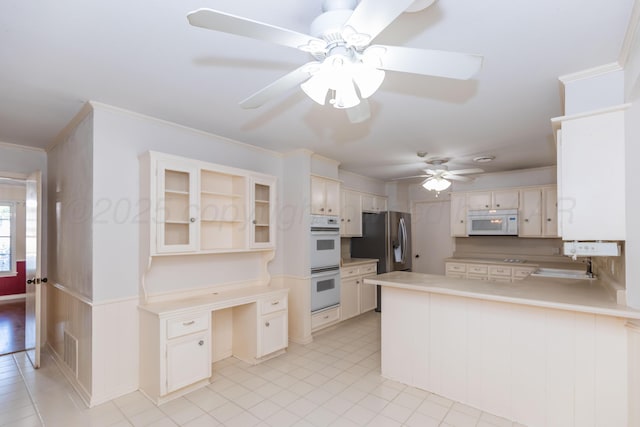 6710 Gainsborough Rd, Amarillo, TX 79106 - kitchen with white appliances, ceiling fan, a peninsula, light countertops, and glass insert cabinets