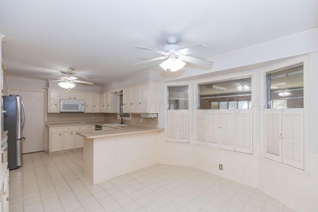 6710 Gainsborough Rd, Amarillo, TX 79106 - kitchen with white microwave, freestanding refrigerator, ceiling fan, a peninsula, and crown molding